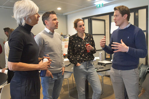 Twee vrouwelijke en een mannelijke medewerker luisteren naar andere mannelijke medewerker tijdens sessie gebiedsplannen